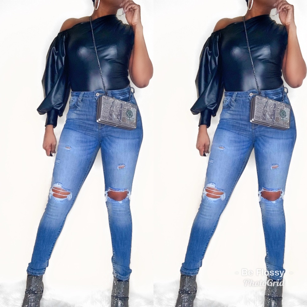 Asymmetrical leather look top with puff sleeve.